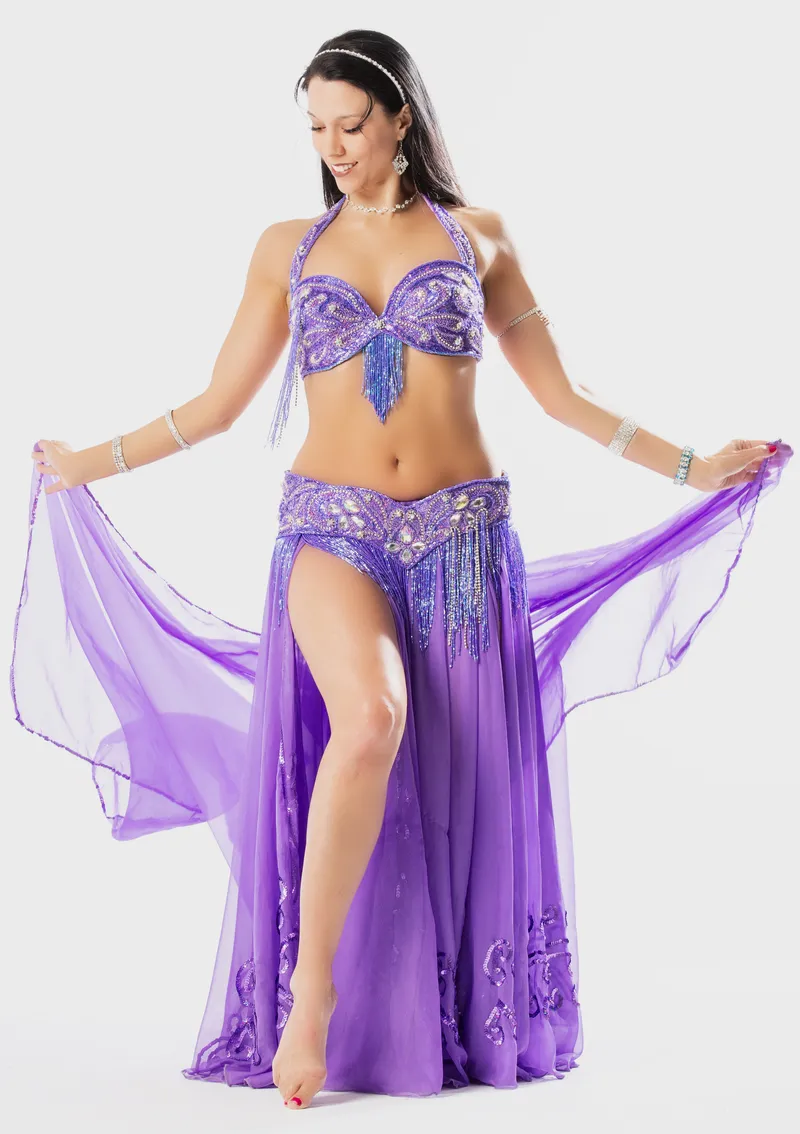 Reischa in a purple beaded costume, sweeping a purple veil
